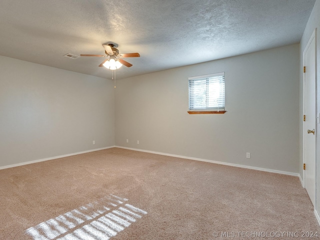 carpeted spare room featuring ceiling fan and a textured ceiling