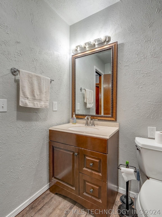 bathroom with vanity, wood-type flooring, and toilet