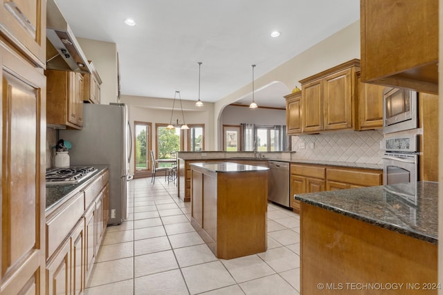 kitchen with pendant lighting, a center island, stainless steel appliances, kitchen peninsula, and light tile patterned floors