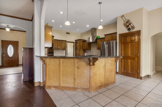 kitchen featuring range hood, ornamental molding, stainless steel refrigerator, and decorative backsplash