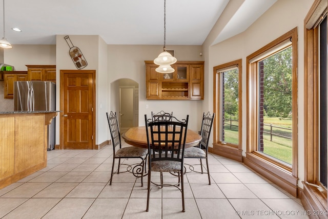 tiled dining space with vaulted ceiling and a wealth of natural light