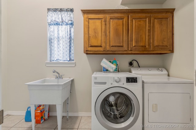 washroom featuring separate washer and dryer, cabinets, and light tile patterned floors