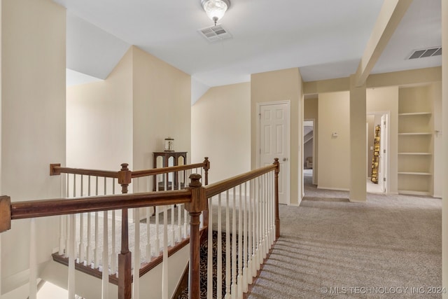 hall with light colored carpet