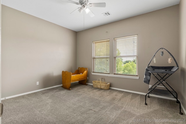 sitting room featuring ceiling fan and carpet