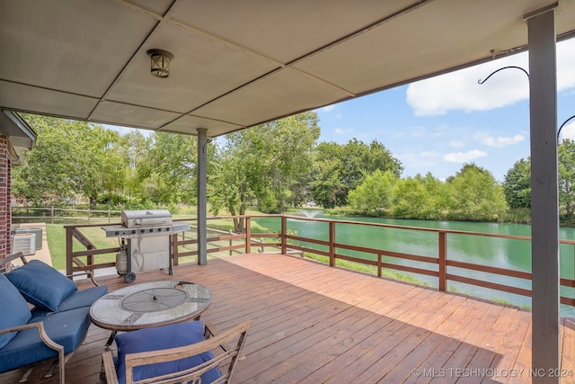 deck with grilling area and a water view