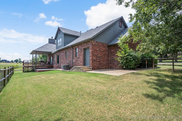 back of house featuring a wooden deck, a yard, and central air condition unit