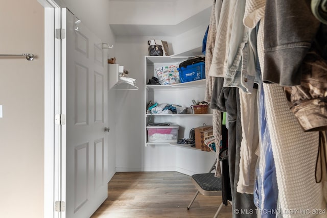 walk in closet with light hardwood / wood-style floors