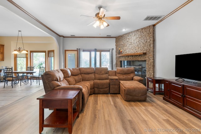 living room featuring ornamental molding, light wood-type flooring, a fireplace, and ceiling fan