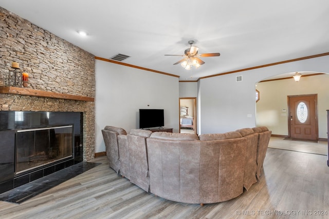 living room with ornamental molding, a fireplace, ceiling fan, and light hardwood / wood-style flooring