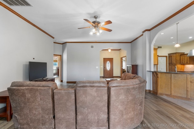 living room with ceiling fan, sink, crown molding, and hardwood / wood-style floors