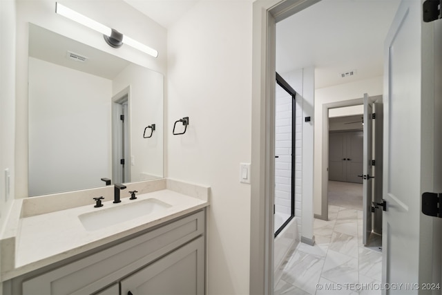 bathroom with vanity and bath / shower combo with glass door