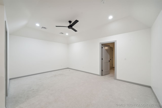 spare room with vaulted ceiling, light carpet, and ceiling fan