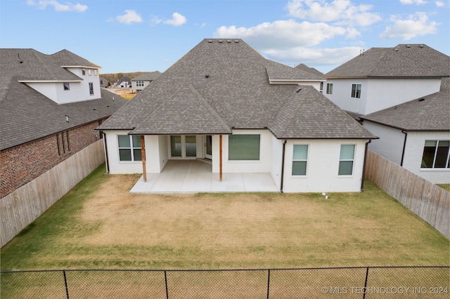 rear view of property with a yard and a patio area