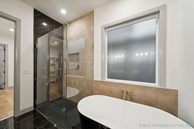 bathroom featuring shower with separate bathtub