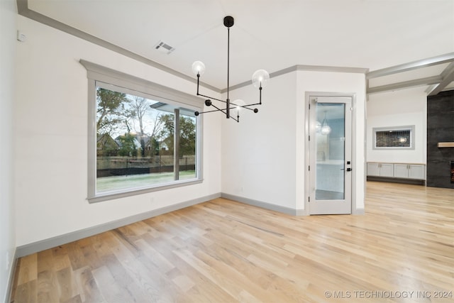 interior space with hardwood / wood-style floors, crown molding, and a chandelier