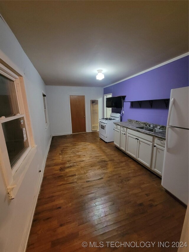 kitchen with sink, dark wood-type flooring, white appliances, and white cabinetry