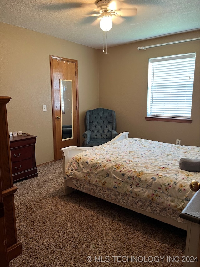 bedroom featuring carpet flooring, a textured ceiling, and ceiling fan