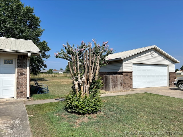 exterior space with a garage and a lawn