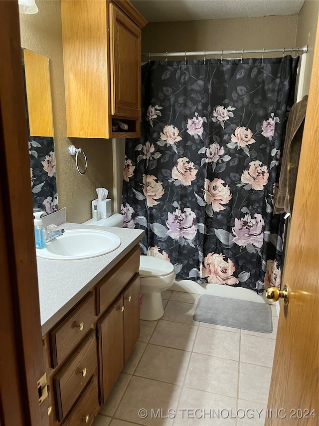 bathroom featuring vanity, tile patterned floors, and toilet