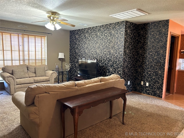 carpeted living room with a textured ceiling and ceiling fan