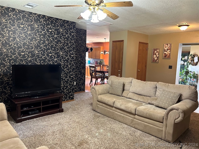 living room featuring carpet, a textured ceiling, and ceiling fan