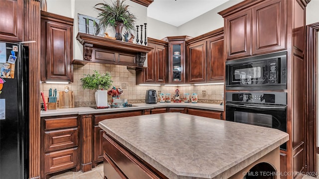 kitchen featuring backsplash, a center island, and black appliances