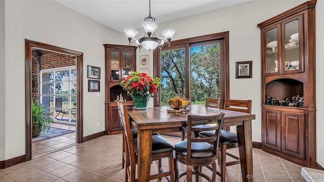 dining space with light tile patterned flooring and an inviting chandelier