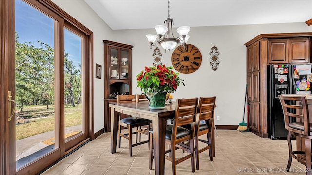 tiled dining room with an inviting chandelier