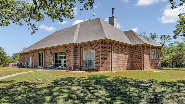 rear view of property featuring a yard and french doors