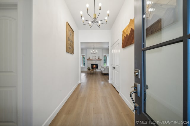 hall featuring a chandelier and light wood-type flooring