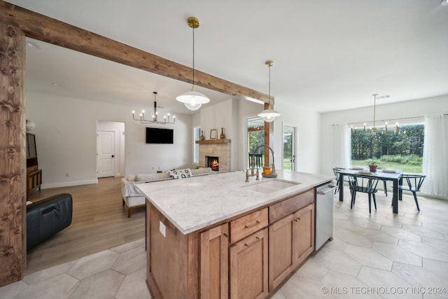 kitchen featuring stainless steel dishwasher, sink, plenty of natural light, and an island with sink