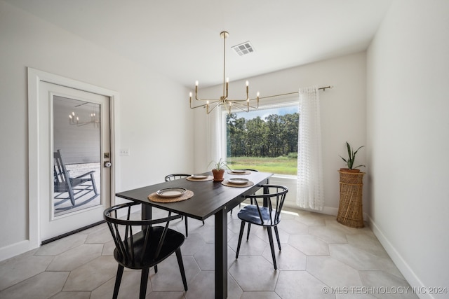 tiled dining area featuring an inviting chandelier