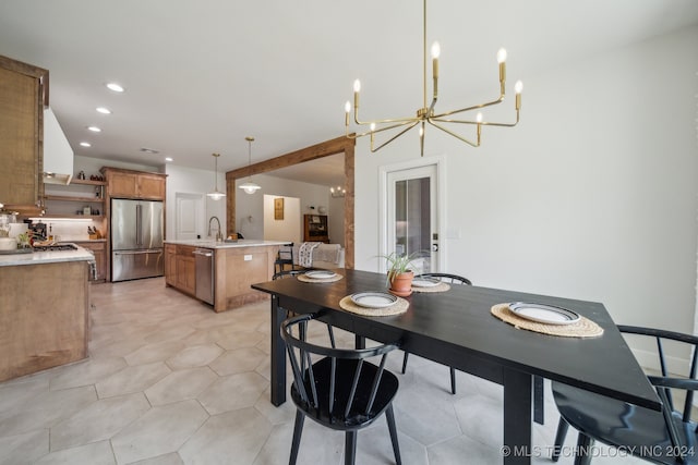 dining room featuring light tile patterned flooring, sink, and an inviting chandelier