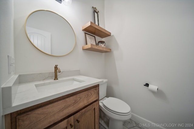 bathroom featuring toilet, vanity, and tile patterned floors