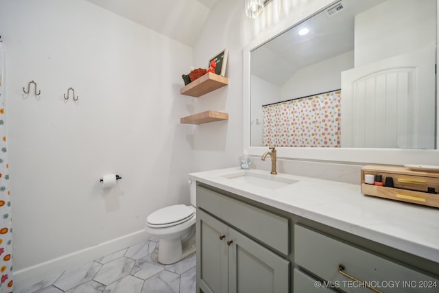 bathroom with toilet, vanity, vaulted ceiling, and tile patterned flooring