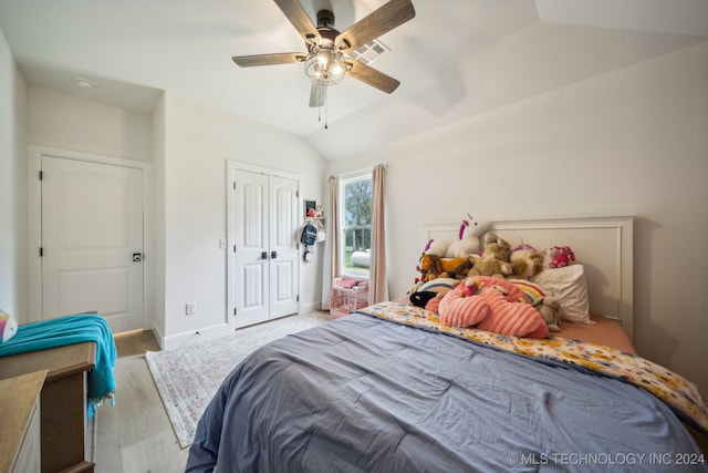 bedroom with light hardwood / wood-style flooring, ceiling fan, a closet, and lofted ceiling