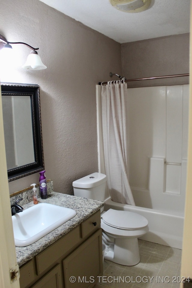 full bathroom with shower / tub combo with curtain, vanity, tile patterned floors, and toilet