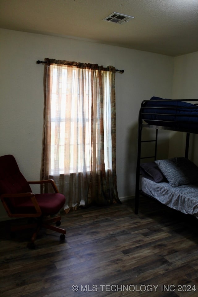 bedroom with multiple windows and hardwood / wood-style flooring