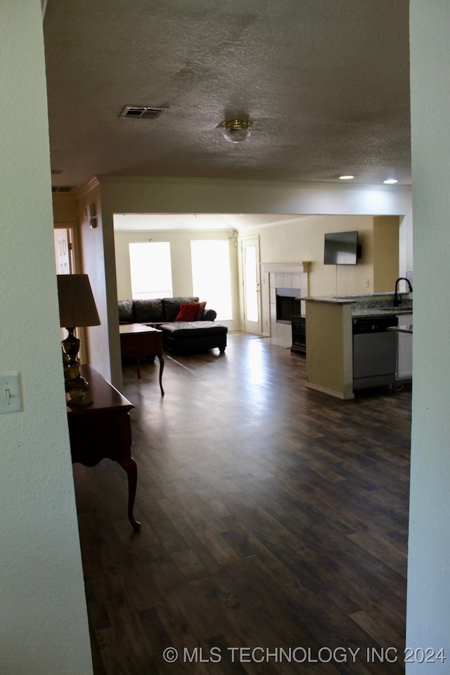 living room featuring sink, dark wood-type flooring, and a textured ceiling