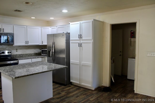 kitchen featuring white cabinetry, a center island, dark wood-type flooring, stainless steel appliances, and decorative backsplash