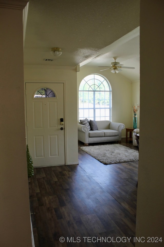 foyer entrance with ceiling fan, vaulted ceiling, dark hardwood / wood-style flooring, and ornamental molding