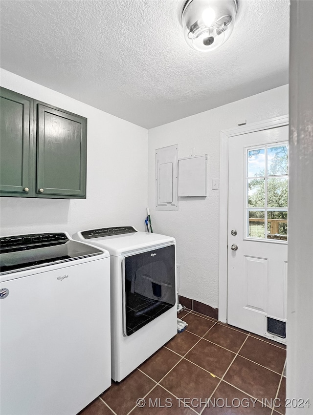 clothes washing area with cabinets, electric panel, washer and dryer, and dark tile patterned floors