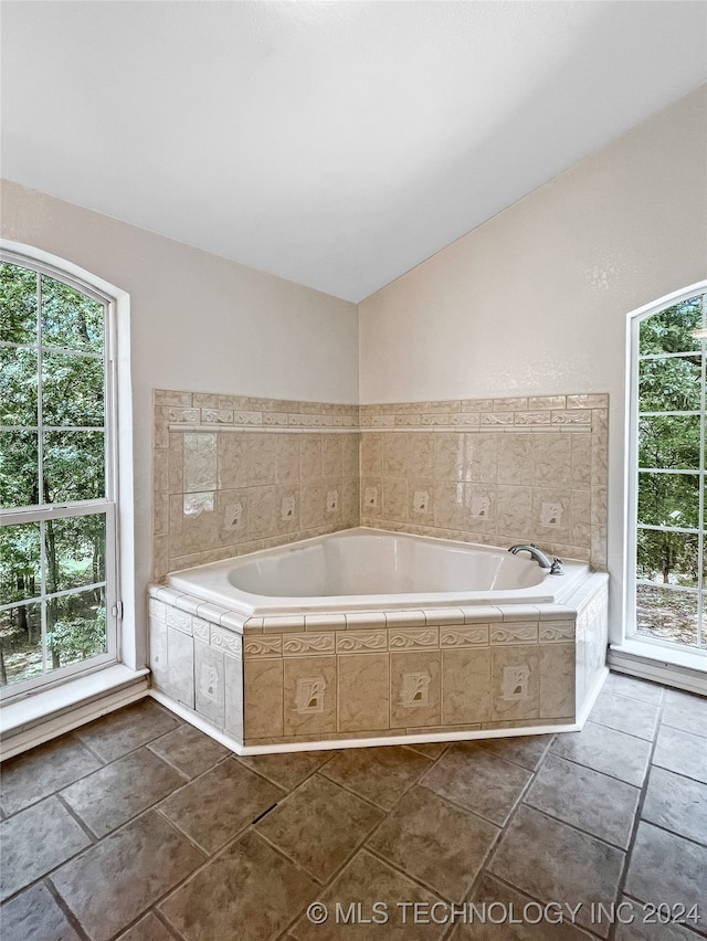 bathroom featuring plenty of natural light, vaulted ceiling, and tile patterned floors