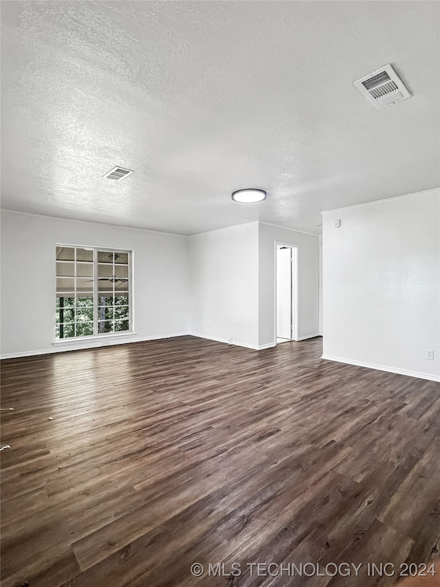 unfurnished living room featuring dark wood-type flooring and a textured ceiling