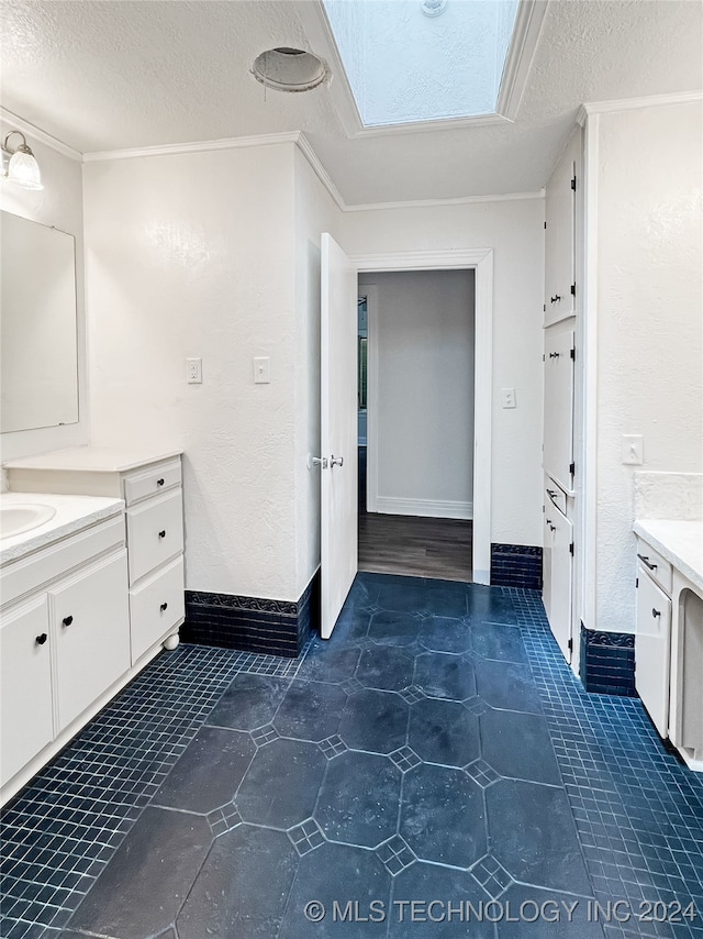 bathroom with tile patterned floors, a skylight, a textured ceiling, and vanity