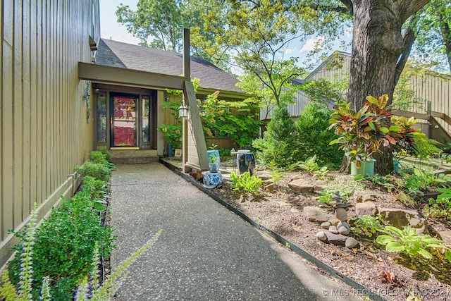 property entrance featuring roof with shingles