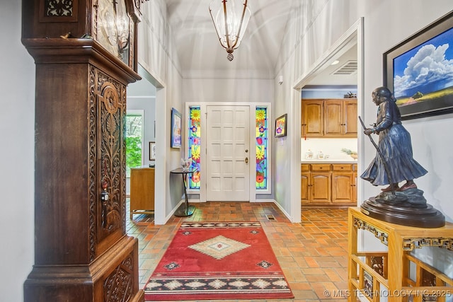 foyer featuring visible vents, baseboards, and brick floor