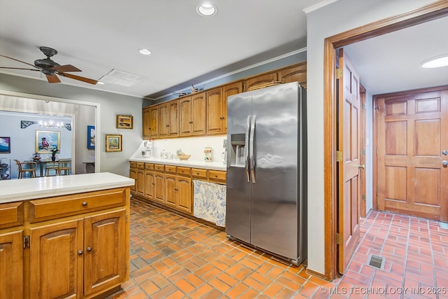 kitchen with recessed lighting, light countertops, brick floor, and stainless steel fridge with ice dispenser