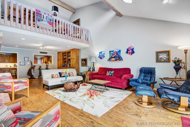 living room featuring hardwood / wood-style flooring, beam ceiling, and high vaulted ceiling