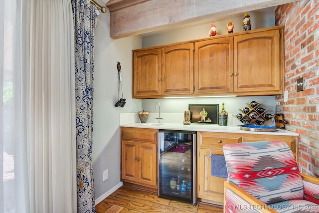 bar with wine cooler, brick wall, sink, and light wood-type flooring